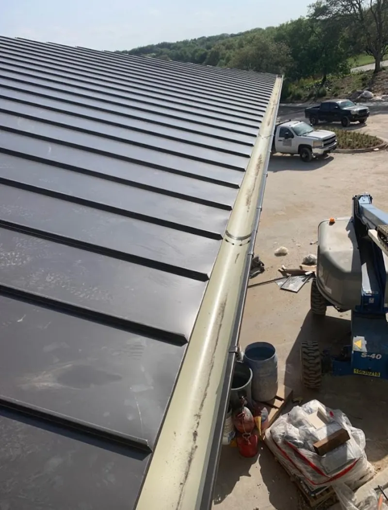 Standing seam panel and gutter detail on a metal roofing jobsite in Buford